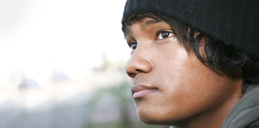 A young biracial man looks sadly into the distance